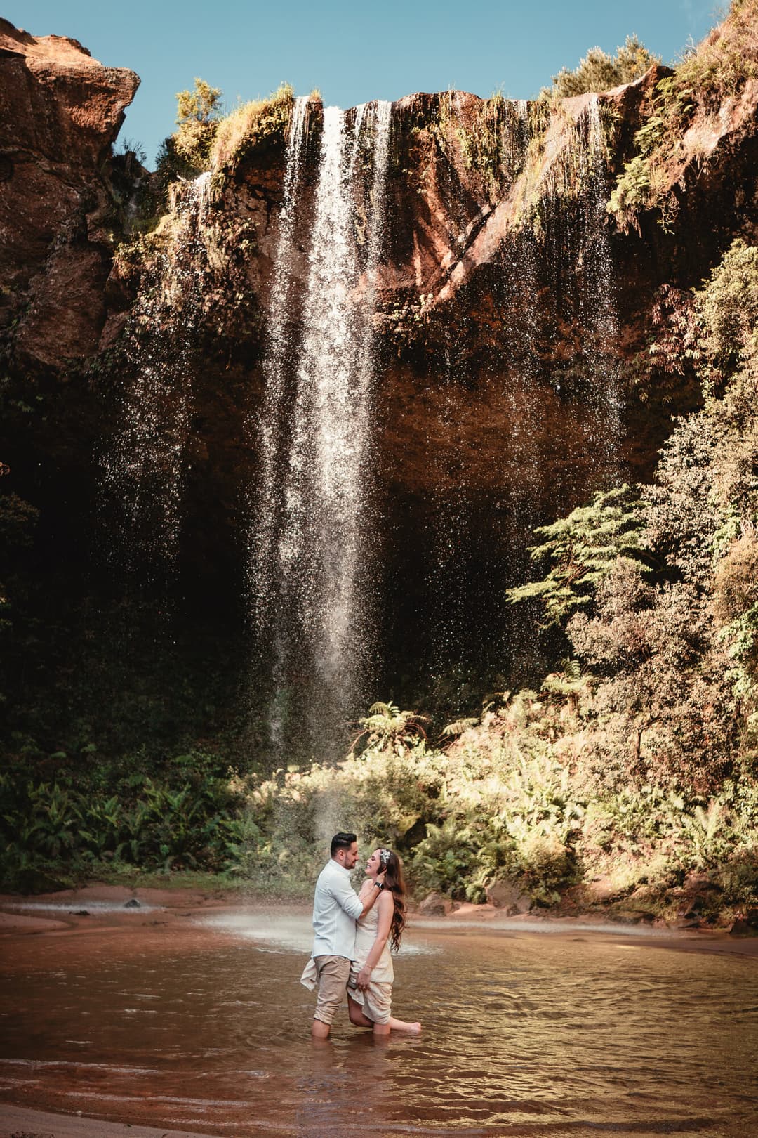 Casal em frente à cachoeira do Espaço do Campo